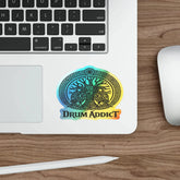 Holographic Drum Addict die-cut sticker featuring a Celtic tree drum design on paper, vibrant and reflective surface.